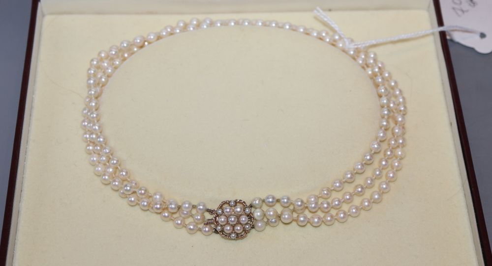 A modern triple strand cultured pearl choker necklace, with 9ct gold and culture pearl cluster clasp, 36cm, gross 33.1 grams.